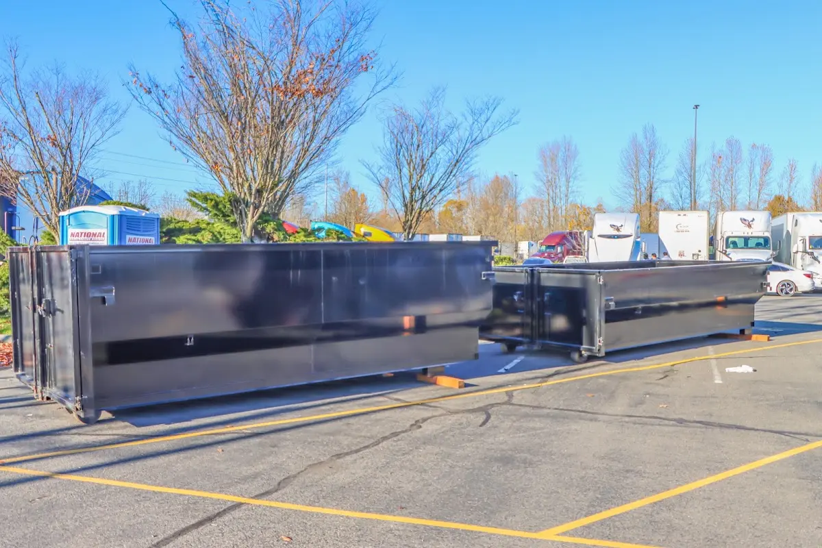 Professional dumpster rental service with roll-off container on residential driveway in Brier